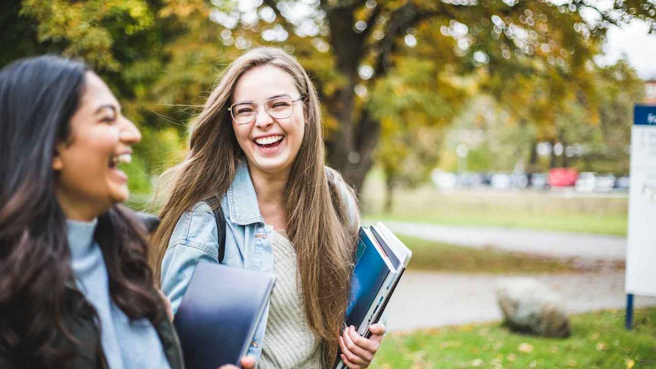 Happy young female friends in university campus