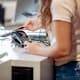 Female college student buying textbooks at a store on campus using her credit card.
