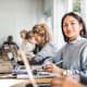 Portrait of confident young woman at desk in classroom