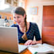 Girl (13-15) doing homework in kitchen