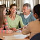 Parents with their high school aged child talking with a financial advisor about college planning.
