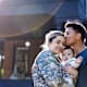 Mid adult man kisses his soldier wife while she holds their baby
