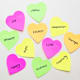 Values such as courage, justice, and creativity handwritten on heart shaped sticky notes.