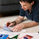 College graduate sitting in his living room paying bills.