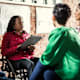 Black businesswoman in a wheelchair leads a brainstorm meeting with colleagues in the office.
