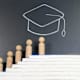 Concept of Graduation. Wooden figurine climbing on top of stacked books with graduation hat drawing on the background.