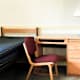 Empty student dormitory room with bed, desk, lamp, chair