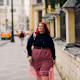 Young red pink haired college student walk at city street outdoors.