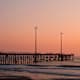 USA, North Carolina, Outer Banks, Kill Devil Hills, pier with wind turbines at sunset