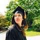 Latina college graduate looking back at the university as she celebrates her commencement.