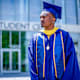 College graduate standing in commencement regalia