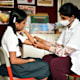 School nurse putting bandage on student's arm