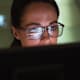 Close-up of a female computer programmer writing code on her desktop computer at work.