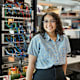Latina electrical engineering college student standing in a tech lab and smiling at the camera.