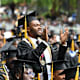 A Black male student graduate stands and claps his hands in celebration during the 2023 Morehouse College Commencement Ceremony at Morehouse College on May 21, 2023 in Atlanta, Georgia.