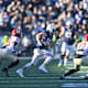 Football players on a field during a Harvard vs Yale game