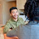 Man smiling while talking to a female colleague in a co-working space.
