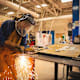 A young teenage high school female is practicing her welding skills while at school.