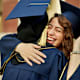 Graduates hugging at commencement
