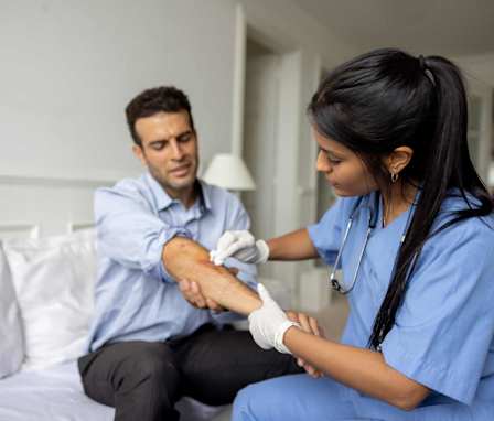 Nurse tending to patient's wound on arm