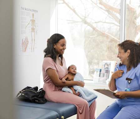 Nurse helping mother with young baby