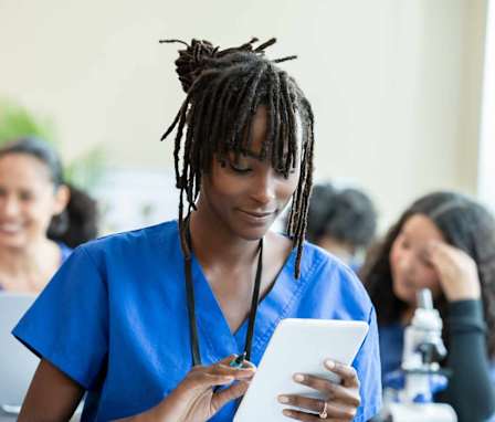 Nursing student working on tablet in classroom