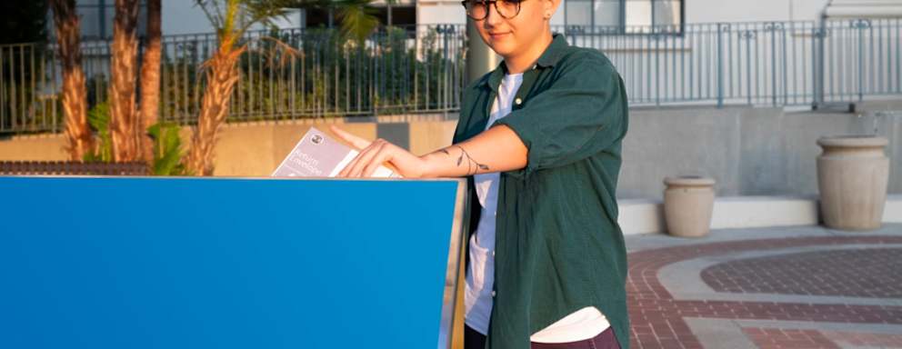 Female college student drops off her absentee ballot into the Official Ballot Drop Box in front of City Hall in Pasadena, California.