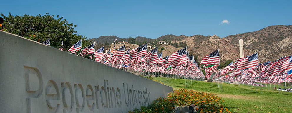 The Pepperdine University sign with a 9-11 memorial flag display in the background.