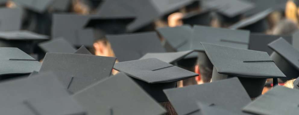 A picture of a large group of graduates wearing their graduation caps. the photo is of the tops of the caps only.