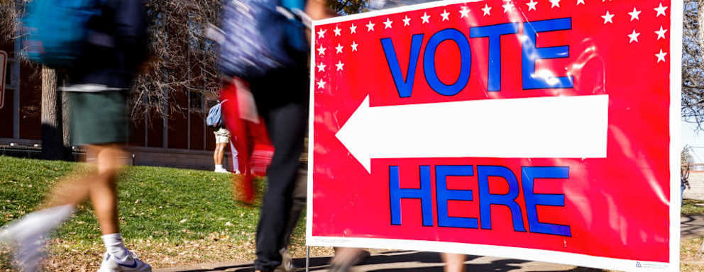 DENVER, CO - NOVEMBER 08: Students walk past a voting sign outside a polling location at Denver East High School on November 8, 2022 in Denver, Colorado. After months of candidates campaigning, Americans are voting in the midterm elections to decide close races across the nation. (Photo by Michael Ciaglo/Getty Images)