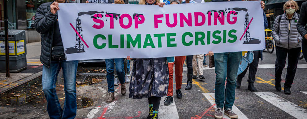 MANHATTAN, NEW YORK, UNITED STATES - 2021/10/29: Participants seen holding a banner at the protest. Hundreds of New Yorkers still reeling from the effects of Hurricane Ida, marched to Citigroup Headquarters and the NY Federal Reserve on to demand two of the citys iconic financial institutions stop the pipeline of money flowing to the fossil fuel industry. The actions were part of a day of international escalation with disruptions targeting financial institutions in 50 cities on six continents to protest the role of the financial sector in fueling the biggest threat to global financial security: climate change. (Photo by Erik McGregor/LightRocket via Getty Images)