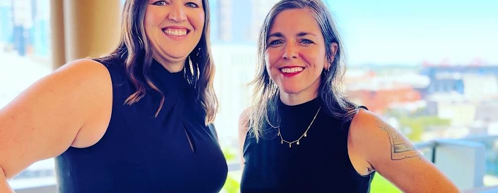 Photo of the two creators of CollegeLeaps, Angie Allen and Laura Vignon. Standing next to one another outside by a balcony.
