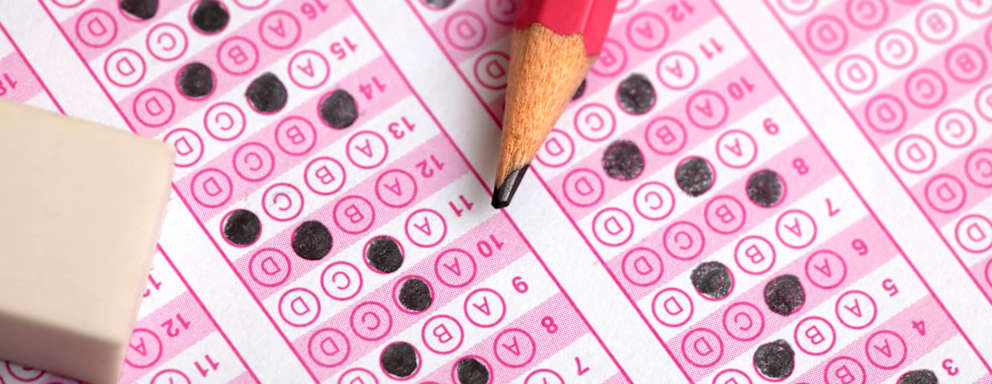 Close up of a student's pencil and eraser on a partially filled out SAT test answer sheet.