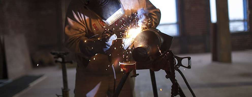 BOSTON, MA - OCTOBER 2: A welder works on a pipe fitting at the new Fraunhofer Building Technology Showcase October 2, 2012 under construction in the Innovation District of Boston, Massachusetts. Included in the building will be the Fraunhofer Center for Sustainable Energy Systems, a testing area for building related industrial firms testing their new systems of sustainable technologies, materials and concepts and monitored by Fraunhofer's Research & Design engineers. Part of the testing facility will include a Building Energy Efficiency Group which works to accelerate development of the next-generation of energy-saving building technologies and practices. The Fraunhofer Institute is Europe's largest applied research organization with over 20,000 staff and offices in Europe, U.S.A., Asia and the Middle East. (Photo by Robert Nickelsberg/Getty Images)