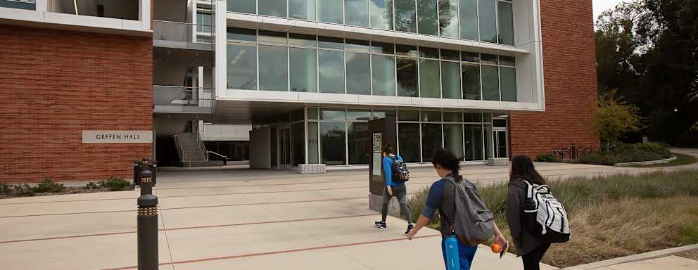 Two students walking toward Geffen Hall on UCLA's Campus.