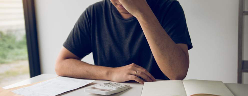 Man With Head In Hands Calculating Bills