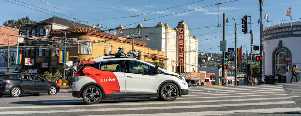 A Cruise autonomous vehicle driving down a busy street