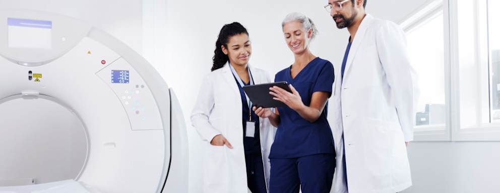 Nurses and doctor looking at a tablet, talking to each other