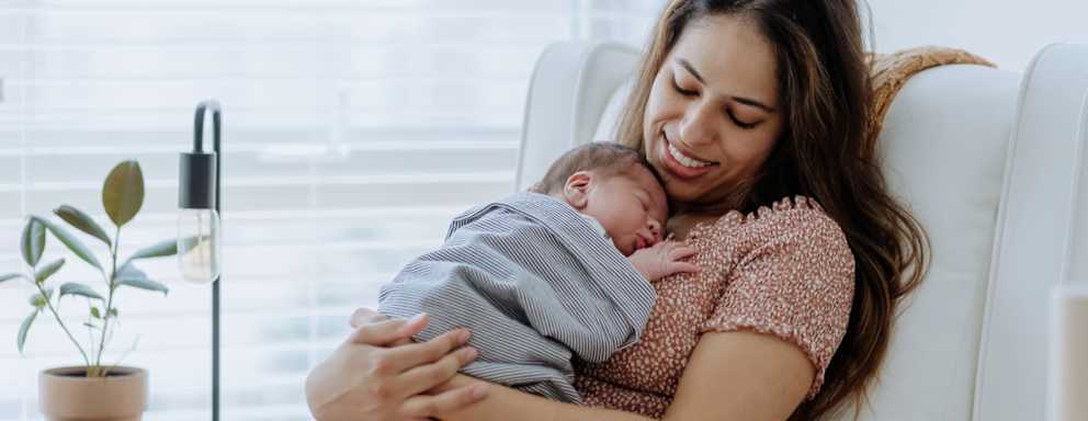 Mother holding newborn baby in nursery