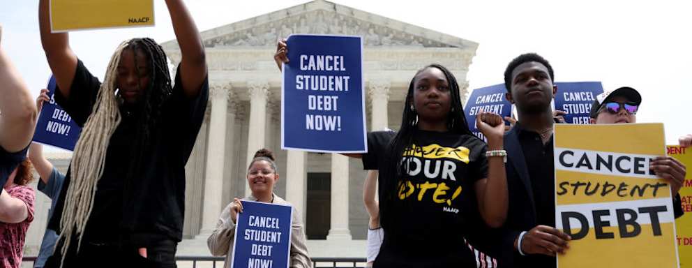 Activists holding signs that read "cancel student debt" outside of the US Supreme Court Building