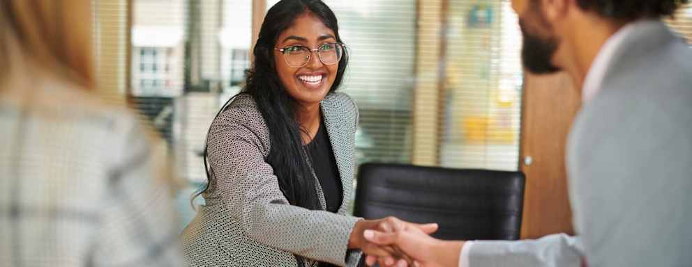 Young business professional shakes hands after a job interview