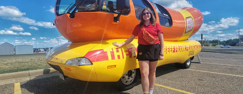Emily Schmitt standing in front of the Frankmobile
