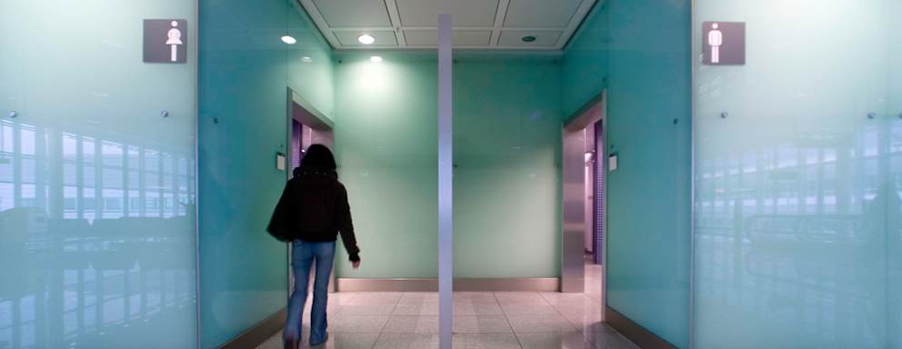 A woman walks into a public restroom.