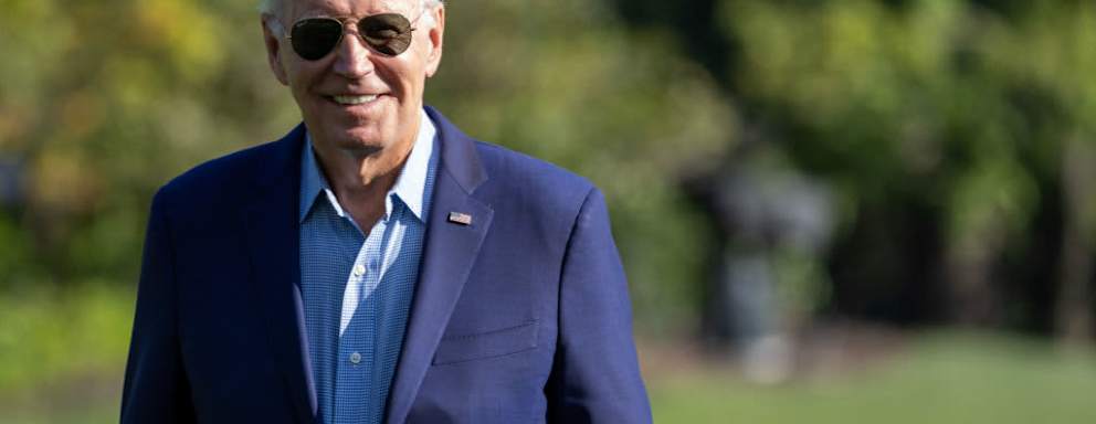 President Joe Biden walking outside and smiling