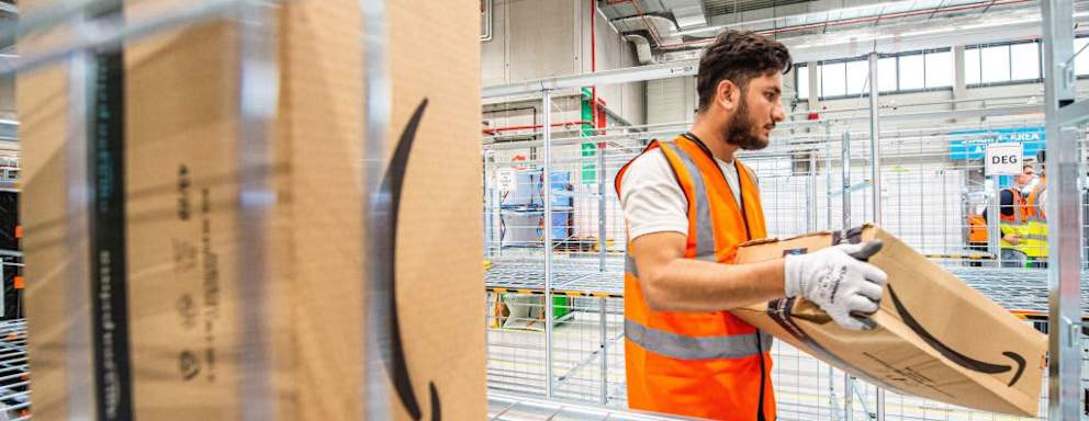 An Amazon employee moves a delivery box in a warehouse