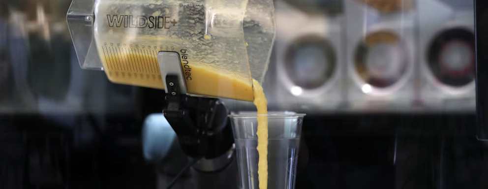 Smoothie pouring out of blender into cup
