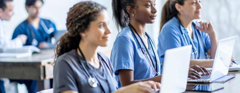 Nursing students taking notes on their laptops in class