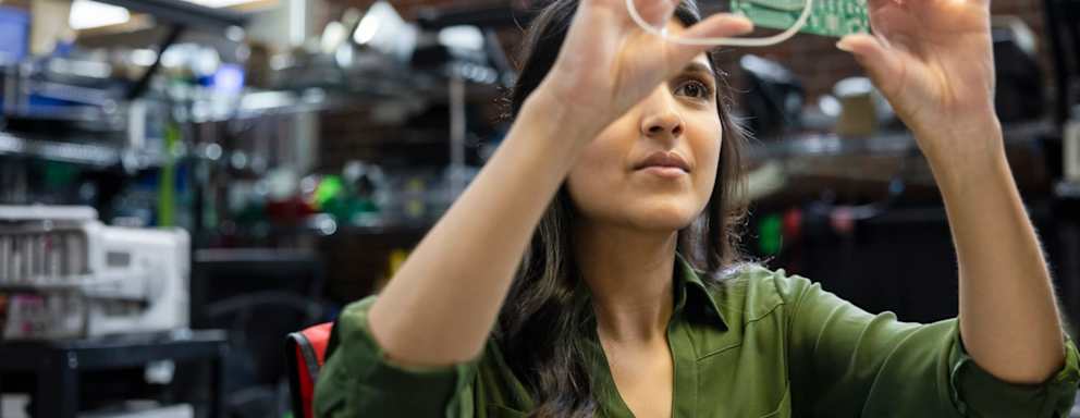 Female engineer inspecting semiconductor in office