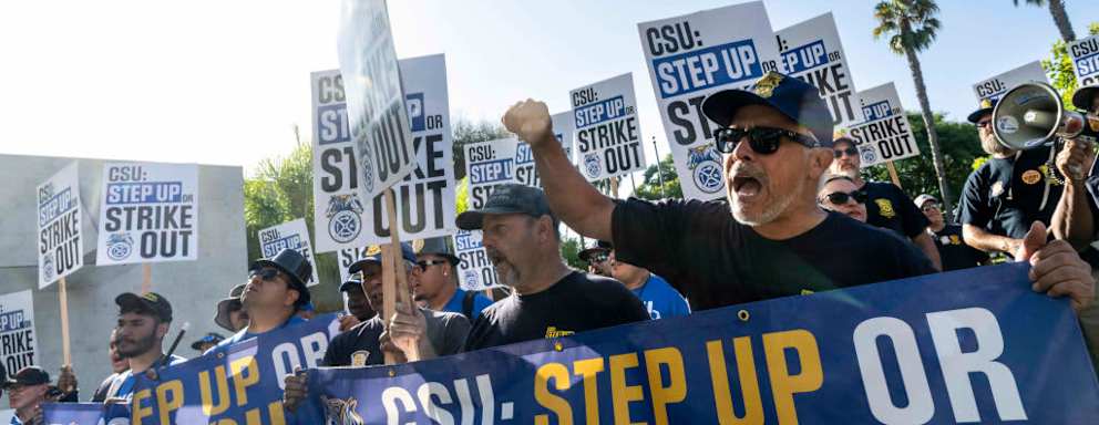 Protestors holding signs that read "CSU: Step Up Or Strike Out"