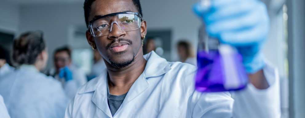 College student examining liquid in the lab